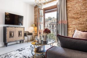 a living room with a couch and a tv and a fireplace at BiBo Suites Plaza Nueva in Granada