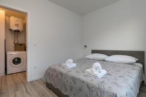 Relax Zone Apartment في ترستنو: غرفة نوم عليها سرير وفوط