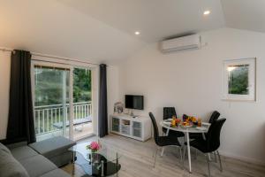 a living room with a couch and a table with chairs at Relax Zone Apartment in Trsteno