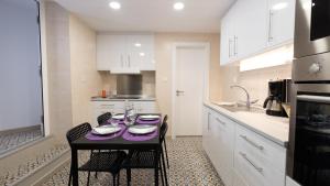 a kitchen with a table with a purple table cloth on it at Casa das 3 Andorinhas in Olhão