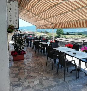 una fila de mesas y sillas en un patio en Albergo La Torre, en Radicofani