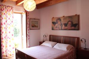 a bedroom with a bed and a painting on the wall at Bed & Breakfast Lucy in Bardolino