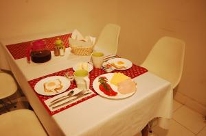 a table with plates of food on it at Hipnotic B&B in Sopot