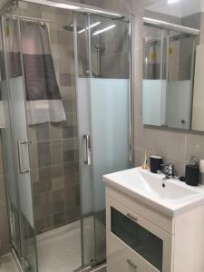 ein Bad mit einer Dusche, einem Waschbecken und einem Spiegel in der Unterkunft #Ocean view studio #WIFI in Icod de los Vinos