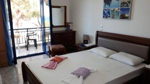 a bedroom with a bed with white sheets and a balcony at Kocheilas Studios in Gialiskari