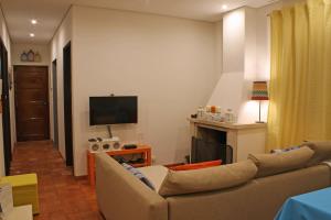 ein Wohnzimmer mit einem Sofa und einem TV in der Unterkunft Quintinha da Evangelina in Açafora