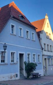 a white building with a bench in front of it at City Apartments Ebern in Ebern