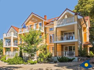 un gran edificio amarillo con balcones y árboles en Parkresidenz "Zwei Linden" Whg 03 en Heringsdorf