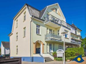 ein großes weißes Gebäude mit Balkon auf einer Straße in der Unterkunft Villa Malve Wohnung 05 in Bansin