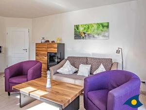 ヘリングスドルフにあるVilla Ilse Whg 05の紫色の椅子とソファ付きのリビングルーム