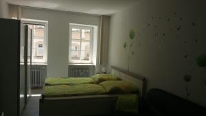 a small bedroom with a bed and two windows at City Apartments Ebern in Ebern
