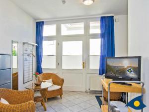 un soggiorno con tende blu e TV di Rolandseck I Whg 04 a Bansin