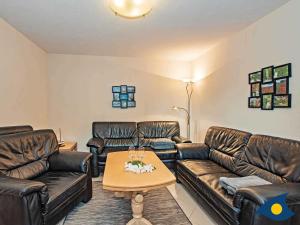 a living room with leather couches and a coffee table at Ferienhaus Melle 02 in Kolpinsee