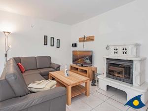 ein Wohnzimmer mit Couch und Kamin in der Unterkunft Ferienwohnung (-haus) Whg. 01 Gartenstraße in Bansin