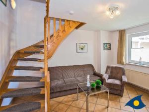 een woonkamer met een bank en een houten trap bij Haus Perle Whg 05 in Heringsdorf