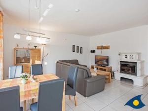 ein Wohnzimmer mit Tisch und Stühlen und einem Kamin in der Unterkunft Ferienwohnung (-haus) Whg. 01 Gartenstraße in Bansin