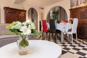 Villa Les Quatre Vents في لا بول: مزهرية من الزهور تجلس على طاولة في غرفة