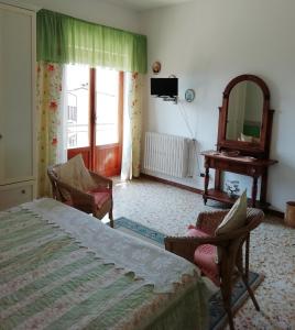 - une chambre avec un lit, deux chaises et un miroir dans l'établissement Albergo La Torre, à Radicofani