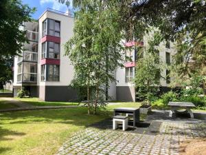 a park with benches in front of a building at Masti Apartment in Tallinn