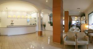 un hall d'un hôpital avec des chaises et un comptoir dans l'établissement Hotel Costa Brava, à Blanes