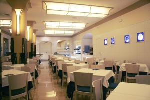 a dining room with white tables and chairs at Hotel Costa Brava in Blanes