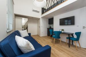 Una sala de estar con un sofá azul y una mesa. en Pearl of Sopot, en Sopot