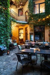 un restaurante con mesas, sillas y plantas en Krakow For You Main Square Apartments, en Cracovia