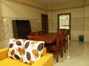 a dining room with a couch and a table and chairs at Madhusmruti in Puri
