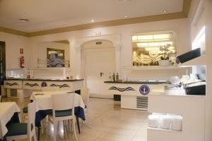 a restaurant with white tables and chairs and a counter at Hotel Costa Brava in Blanes