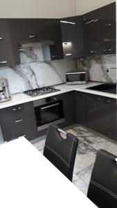 - une cuisine avec des comptoirs en marbre noir et blanc dans l'établissement MONAR City center apartment free parking, à Košice
