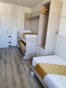 two beds in a room with wooden floors and wooden floorsktop at Residence La Margherita in Lazise