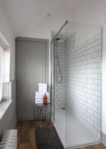 a shower with a glass door in a bathroom at The Stable, Yew Tree Farm Holidays, Tattenhall, Chester in Chester