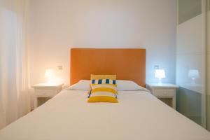 1 dormitorio con 1 cama blanca grande y 2 lámparas en APARTAMENTO LOS REMOS DE LA GRACIOSA, en Caleta de Sebo