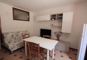 cocina con mesa, sillas y sofá en Casetta delle Arti, en Mondragone