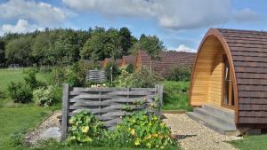 a garden with a wooden fence and some flowers at Willowherb Glamping Pod in Cheltenham