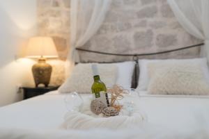 a basket with a bottle of wine and glasses on a bed at Apartment Saint Michael in Šibenik