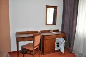 a wooden desk with a chair and a mirror at Penzion Diana in Piešťany