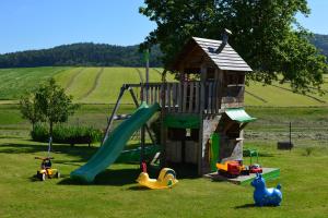 a playground with a slide and toys in the grass at Haus Marie in Thurmansbang