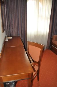 stół i krzesło w pokoju z oknem w obiekcie Penzion Diana w Pieszczanach