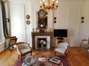 a living room with a fireplace and a tv at Château de Cleuville in Cleuville