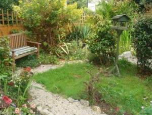 a garden with a bench and a gazebo at Trelawney Guest House Room only in Falmouth