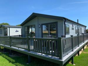 a green modular house with a porch on a deck at St Helens Coastal Resort in Saint Helens