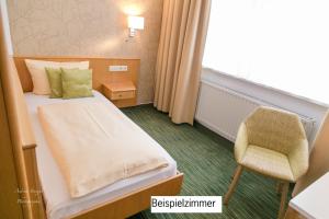 Habitación de hotel con cama y silla en Waldhotel Linzmühle, en Kahla