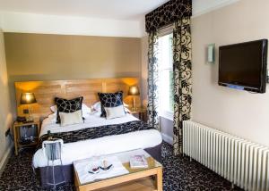 a hotel room with a bed and a flat screen tv at St Elizabeth's House in Plymouth