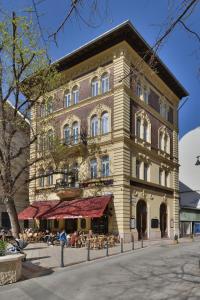 ein großes Gebäude mit Leuten, die draußen sitzen in der Unterkunft Gerlóczy Boutique Hotel in Budapest