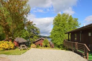 a gravel road leading to a cabin with trees and buildings at Dolphin Run in Hunters Quay