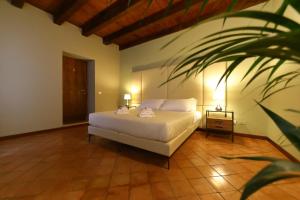 a bedroom with a white bed and a plant at Osteria Luxury Apartments in Peschiera del Garda