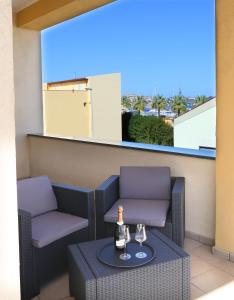 a patio with two chairs and a table with wine glasses at Hotel Milazzo in Milazzo