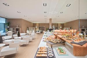 a buffet line in a restaurant with white chairs at Melia Sitges in Sitges