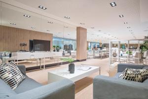 a living room with two couches and a tv at Melia Sitges in Sitges